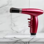 Revlon One-Step Hair Dryer and Volumizer Hot Air Brush on white marble bathroom countertop.